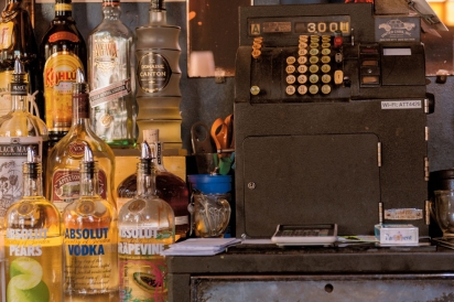 Older cash register and bottles of liquor